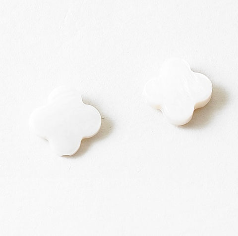 White stud earrings in the shape of rounded edge crosses.