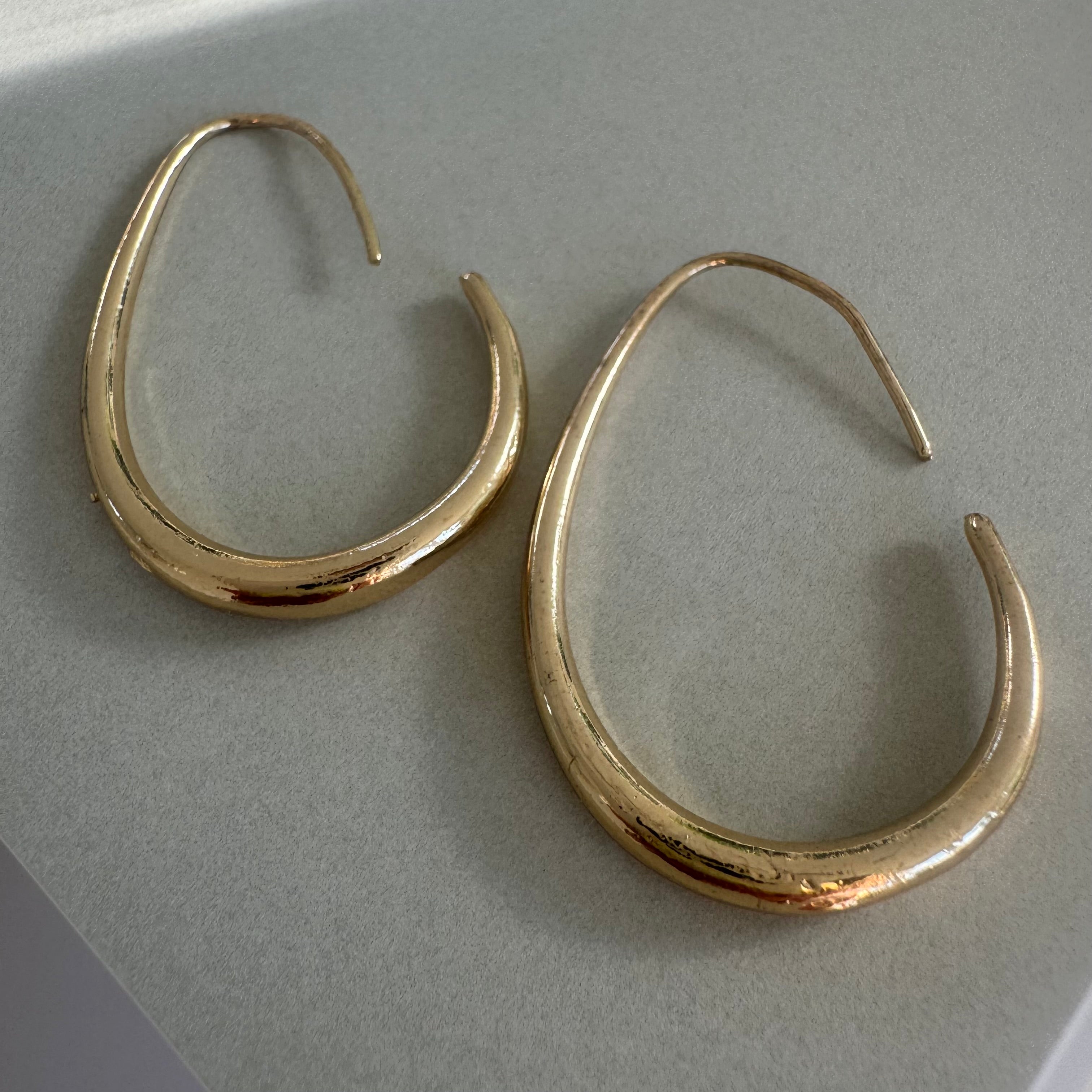 Gold teardrop hoop earrings.