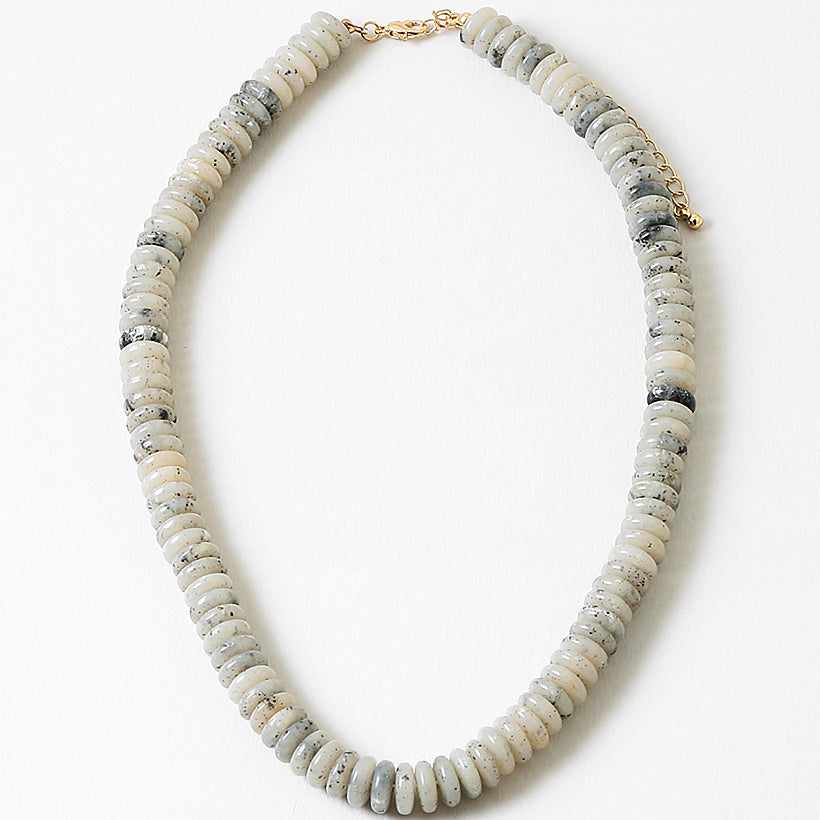 Necklace with white and black stone beads on a white background