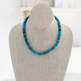 A semi-precious stone necklace with shades of blue beads displayed on a mannequin bust.