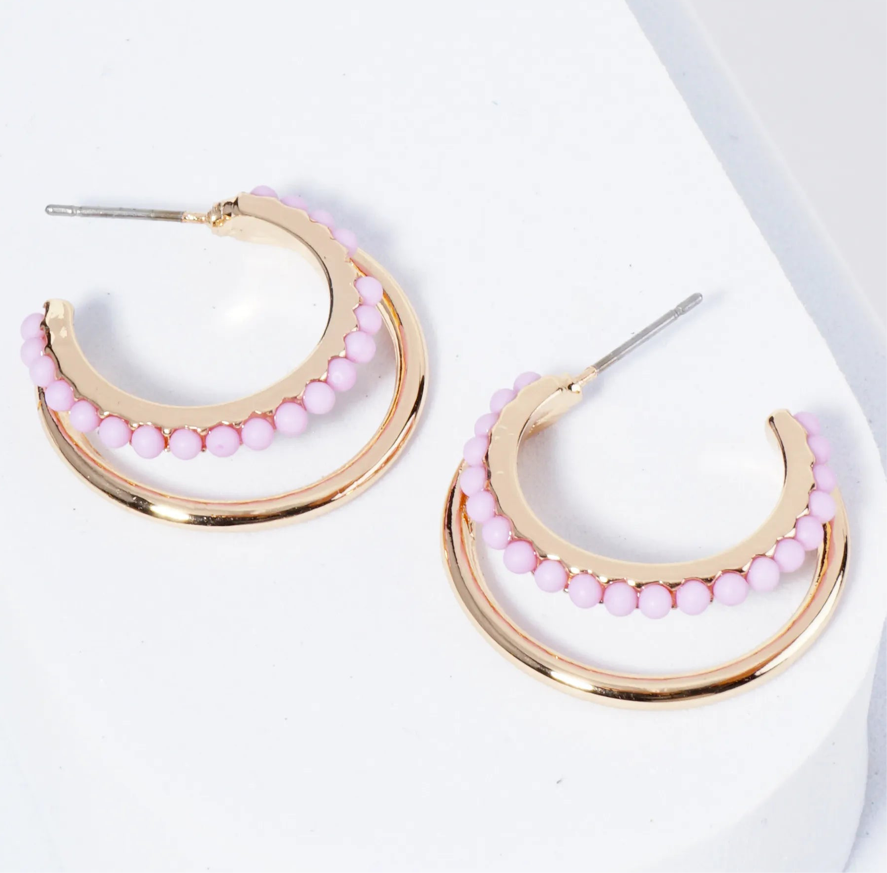 Set of double Gold hoops, one of the hoops is lined with light purple beads.