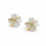 Pair of white four-petal flower earrings with gold accents on a white background