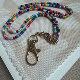 Picture of a multicolored beaded lanyard with a large gold clasp.