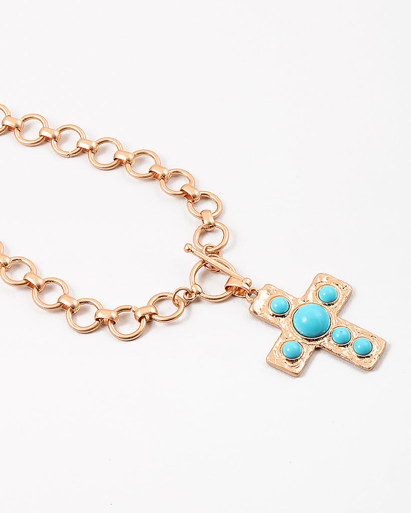 Large circle link gold chain with a toggle clasp. Necklace has a gold Cross with turquoise beads set in it as a pendant.