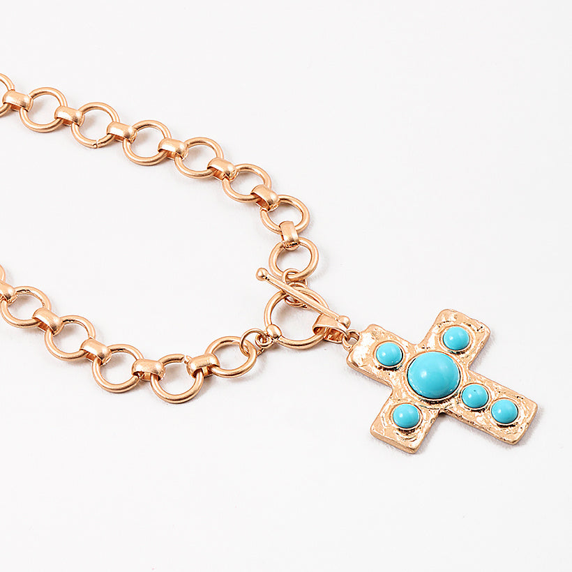 Large circle link gold chain with a toggle clasp. Necklace has a gold Cross with turquoise beads set in it as a pendant.