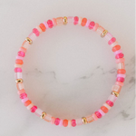Picture of a single beaded bracelet in alternating colors of pink, coral, gold and white