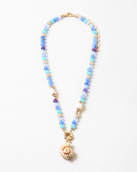 Picture of a blue and coral colored bead necklace with a large seashell pendant.