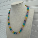 Picture of a necklace made of purple, blue, white, yellow and pink beads.
