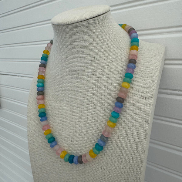 Picture of a necklace made of purple, blue, white, yellow and pink beads.