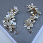 Set of earrings made up of clusters of white flowers and fresh water pearls.