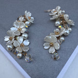 Set of earrings made up of clusters of white flowers and fresh water pearls.