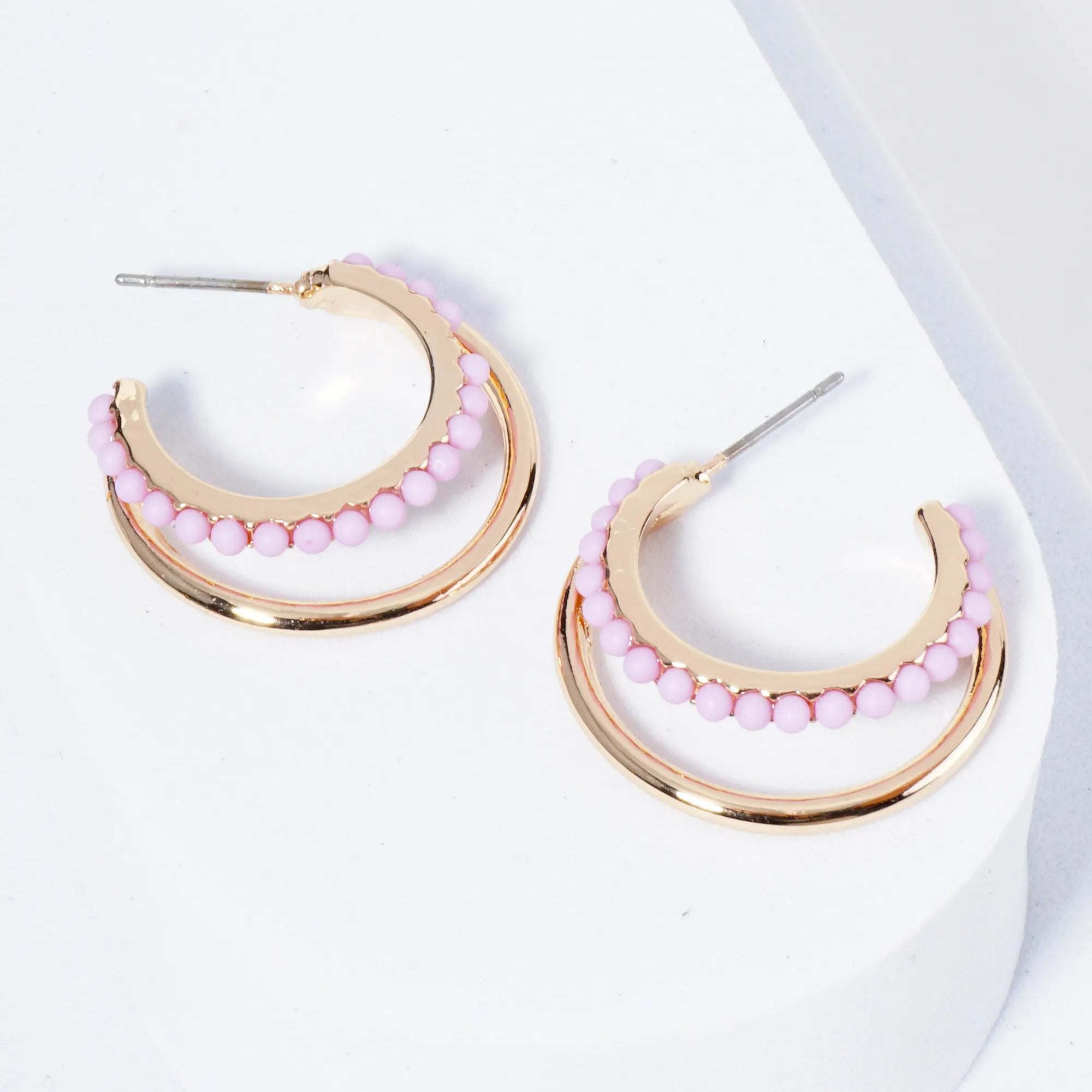 Set of double Gold hoops, one of the hoops is lined with light purple beads.