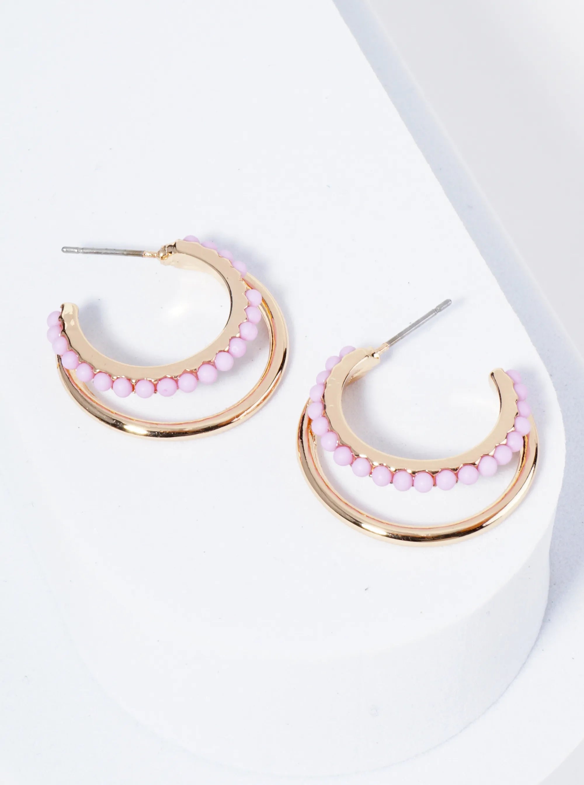 Set of double Gold hoops, one of the hoops is lined with light purple beads.