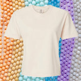 An image of a cream t-shirt with a rainbow colored beaded  background