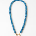 Blue beaded necklace with a gold clasp on a white background