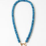 Blue beaded necklace with a gold clasp on a white background