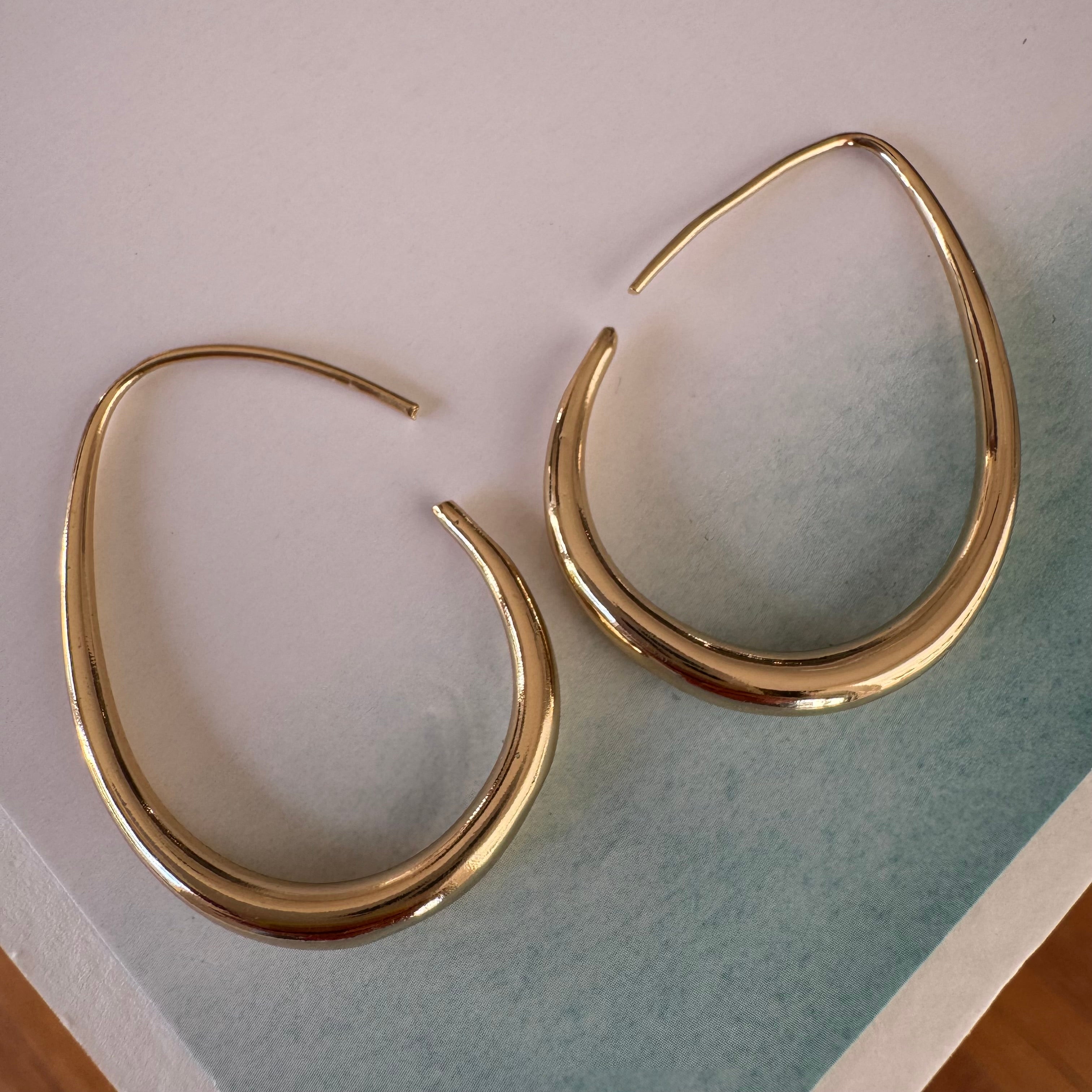 Gold teardrop hoop earrings.