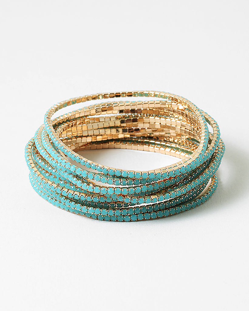 Set of gold beaded bracelets with tiny turquoise stones on a white background