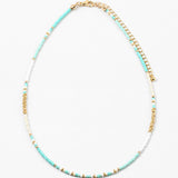 Picture of a dainty bead necklace made of turquoise, white and gold spacer beads.
