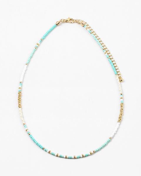 Picture of a dainty bead necklace made of turquoise, white and gold spacer beads.