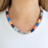 Colorful beaded necklace worn by a person on a plain background