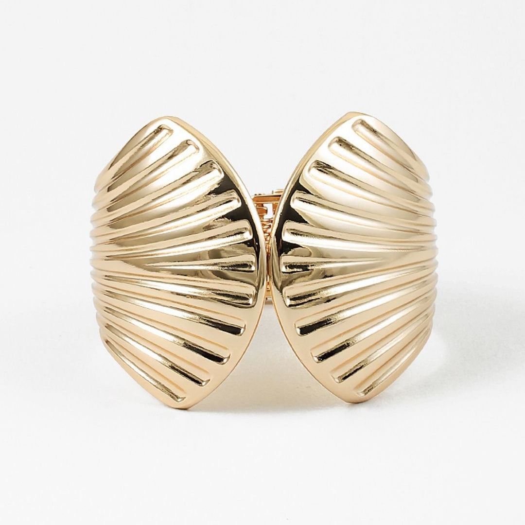 Gold shell-shaped cuff bracelet on a white background