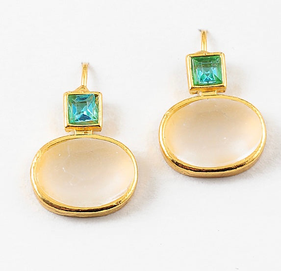 Gold earrings with green gemstones and oval milky stones on a white background