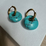 Small gold hoop threaded through a turquoise disc bead.
