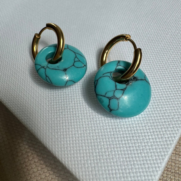 Small gold hoop threaded through a turquoise disc bead.