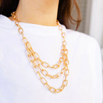 A girl wearing a multi layered gold chained necklace