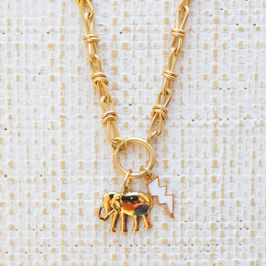 Picture of a gold toggle chain with a golden elephant charm and white lightening bolt.