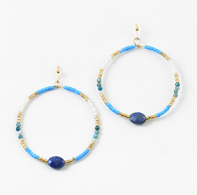 Pair of hoop earrings with blue, gold, and white beads on a white background