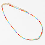 Multicolored rainbow beaded necklace with a gold chain on a white background