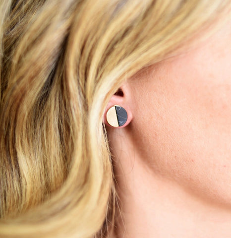 Picture of model wearing a disc stud that is half black and half cream colored.