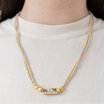 Picture of two braided strands that form a necklace with an evil eye pendant at its center.