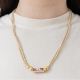 Picture of two braided strands that form a necklace with an evil eye pendant at its center.