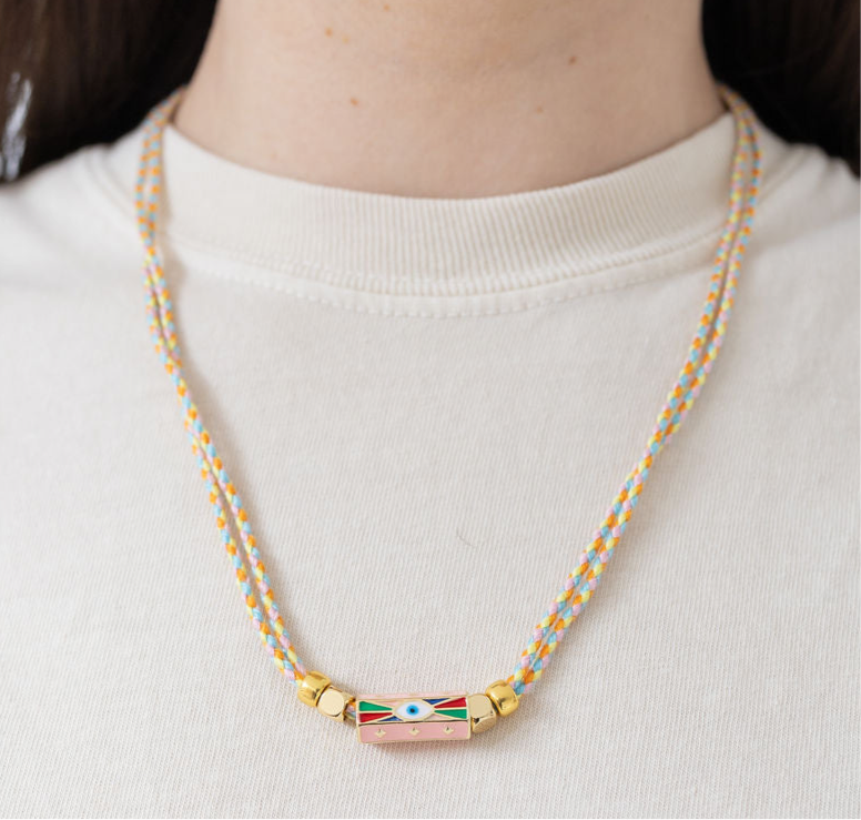 Picture of two braided strands that form a necklace with an evil eye pendant at its center.
