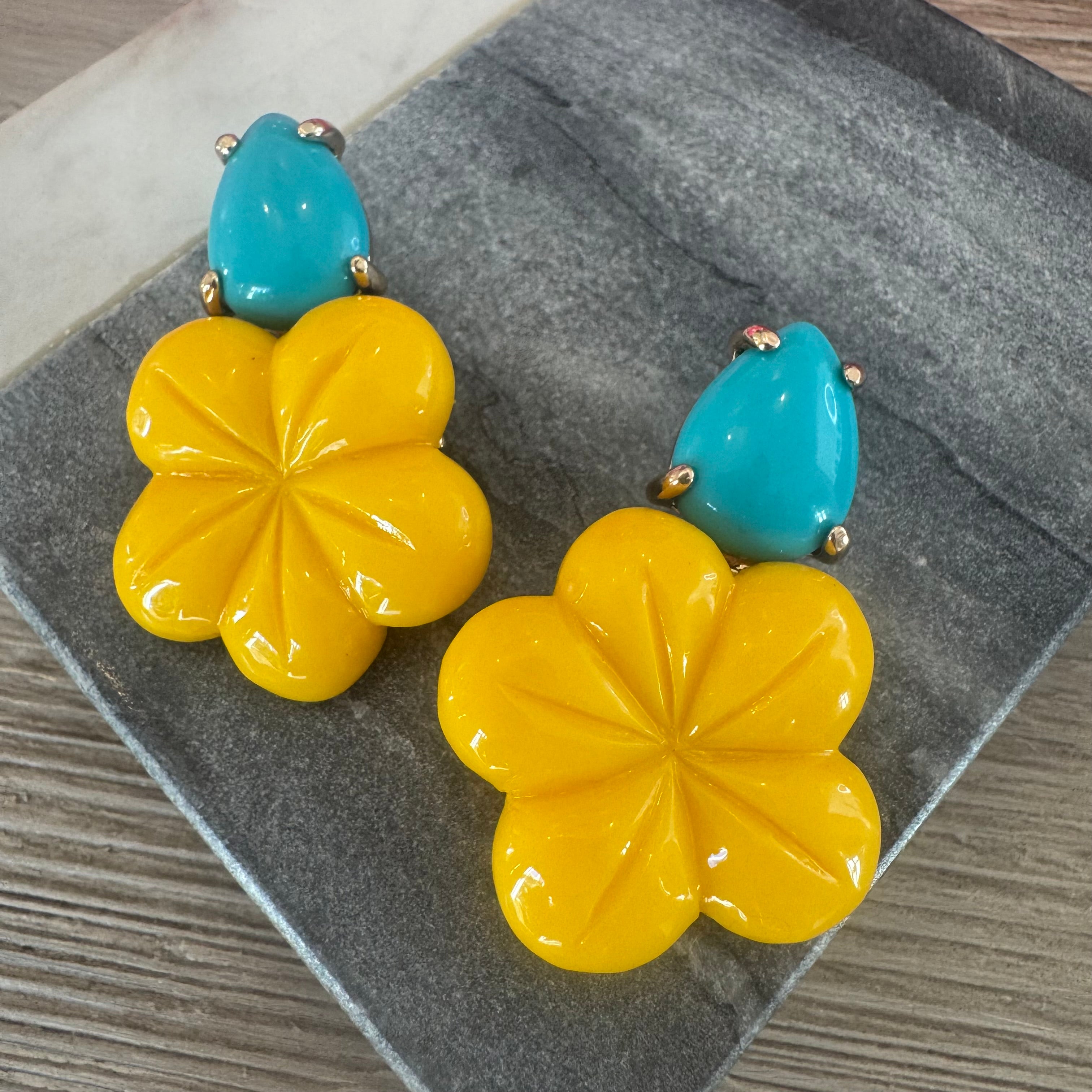 Picture of a pair of earrings with yellow flowers topped by turquoise teardrop beads.