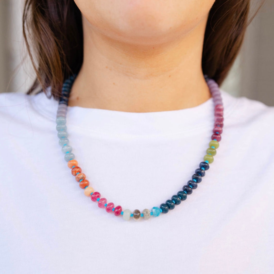 Girl wearing a multi-colored beaded short necklace around her neck
