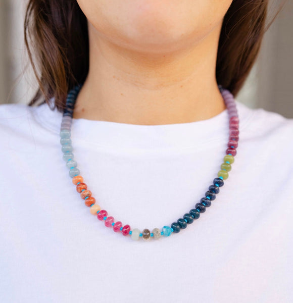 Girl wearing a multi-colored beaded short necklace around her neck