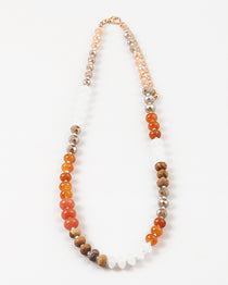 Necklace with multicolored brown, orange and white beads on a white background