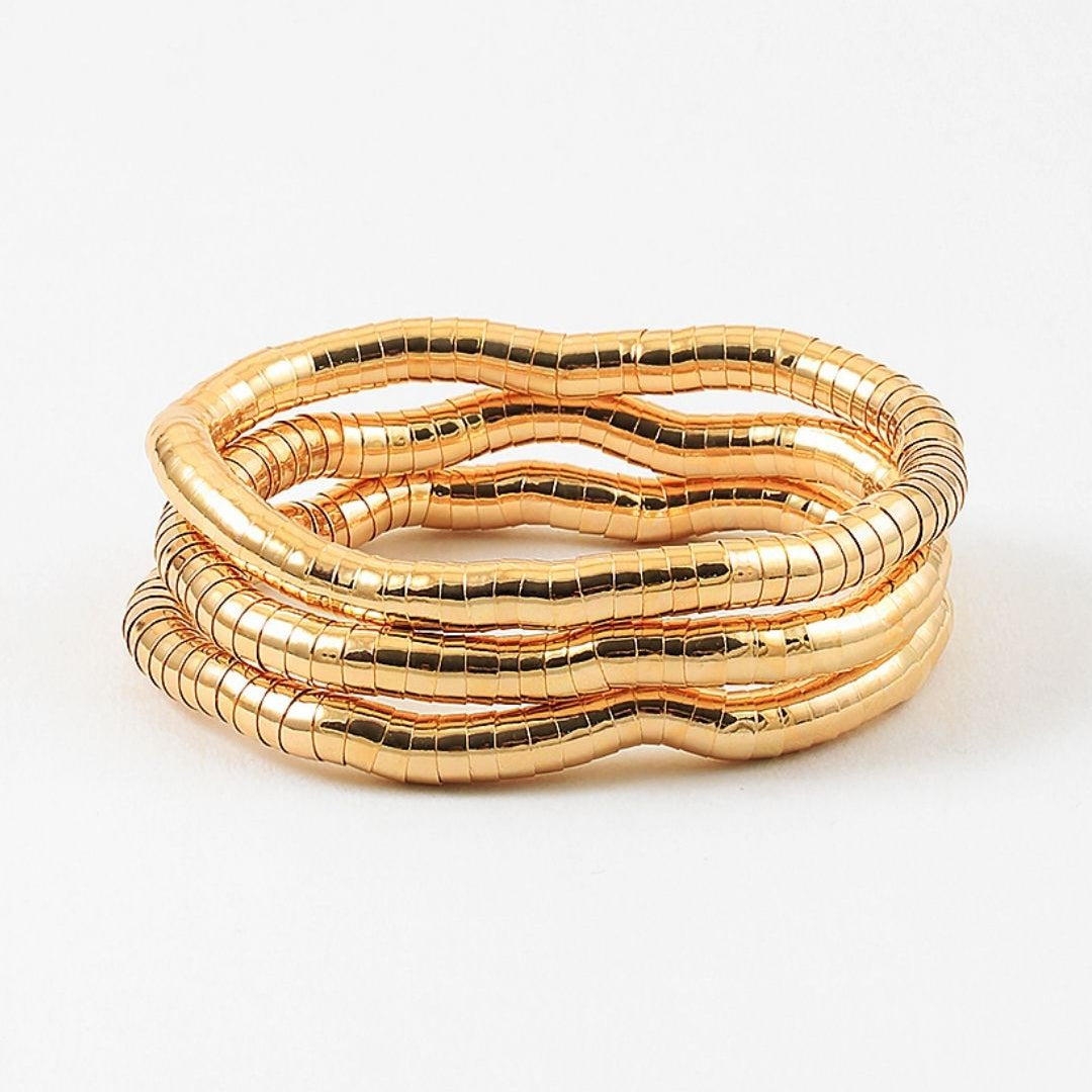 Set of three gold stretch bracelets on a white background