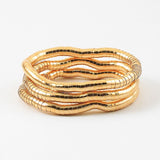 Set of three gold stretch bracelets on a white background
