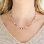 Necklace with pink and multicolored beads worn by a person