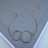 Delicate gold chain with two large gold hoops linked together at its center.