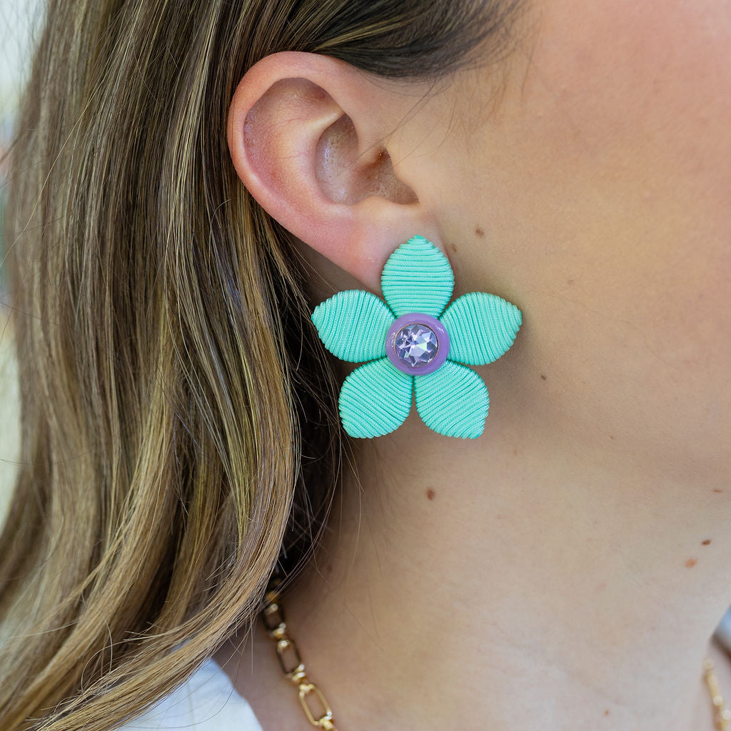 Picture of a large blue woven flower earrings with a purple diamond center.