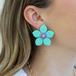 Picture of a large blue woven flower earrings with a purple diamond center.