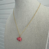 Picture of a dainty gold chain with a pink elephant charm.