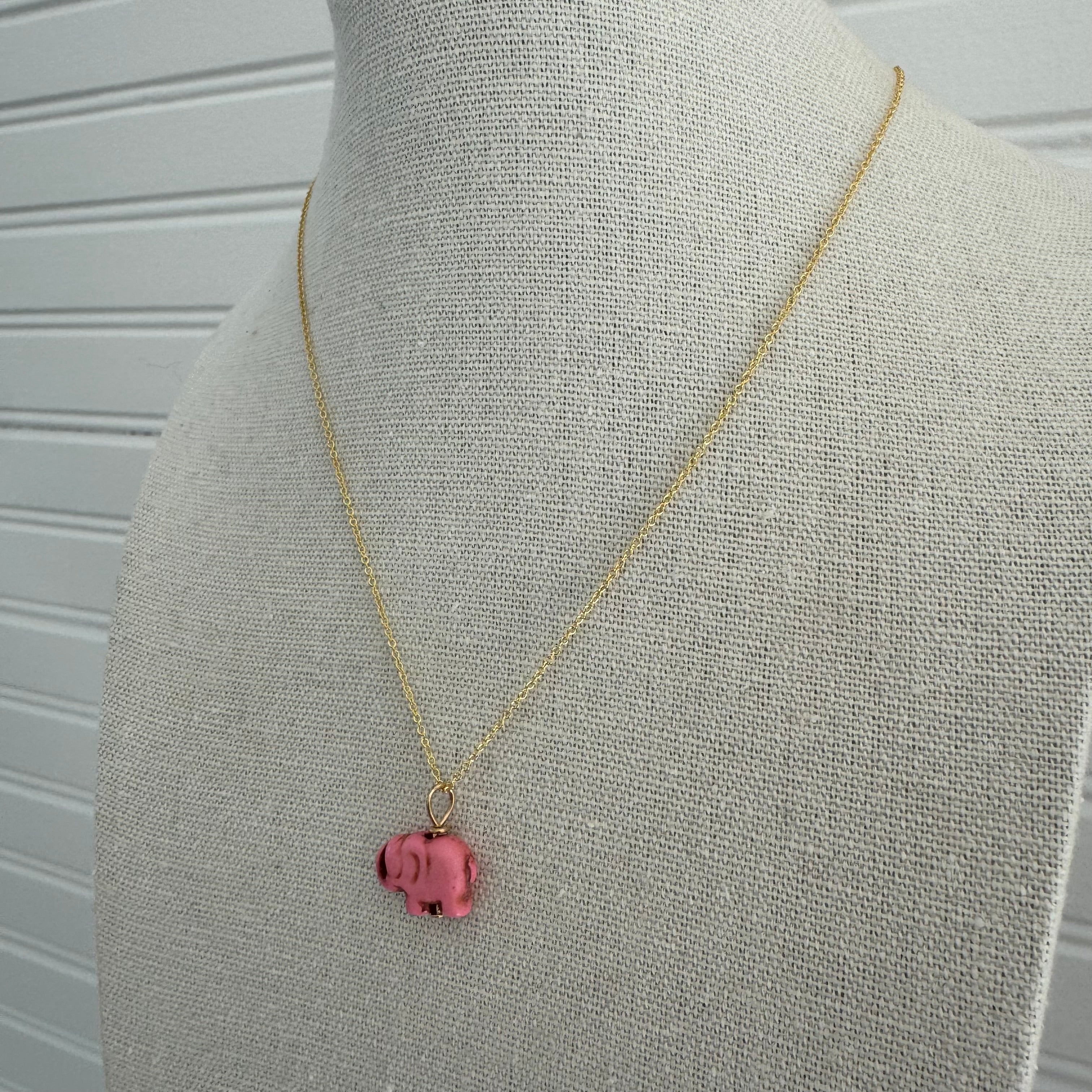 Picture of a dainty gold chain with a pink elephant charm.