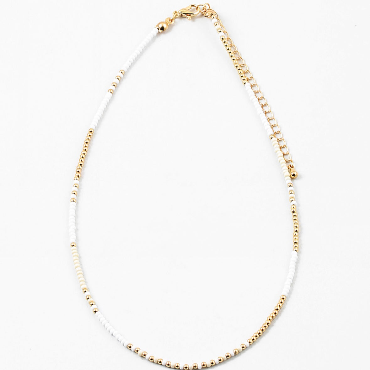 Dainty bead necklace made of white and gold beads.